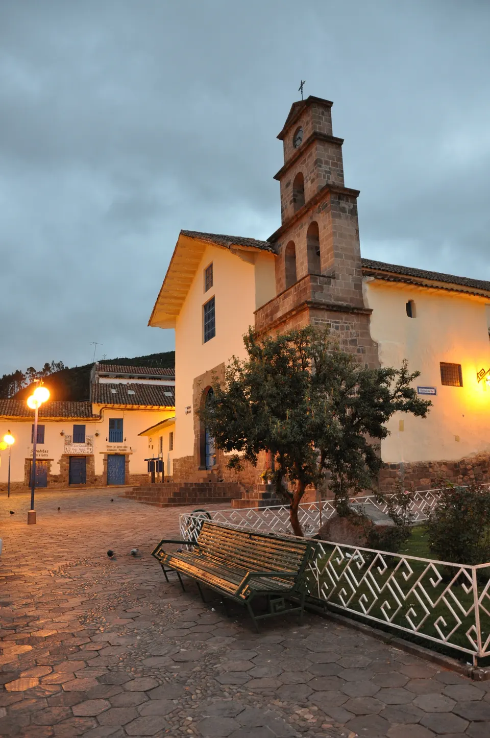 Callejón empedrado y casonas blancas con carpinterías azules en el barrio tradicional de San Blas en Cusco