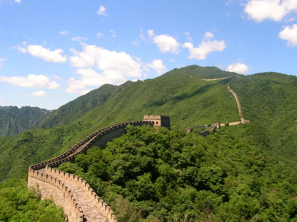 La monumental Gran Muralla China serpenteando sobre las verdes crestas montañosas de Mutianyu, Pekín.