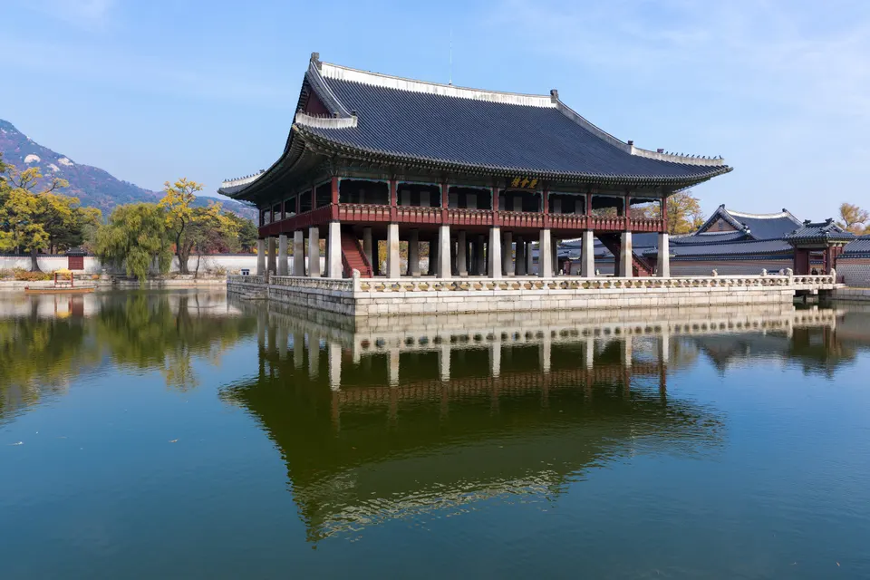 Pabellón real y patios ancestrales del Palacio Gyeongbokgung con el skyline moderno de Seúl de fondo.