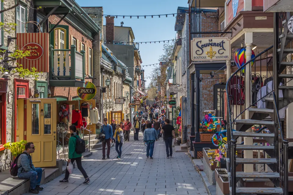 Calles adoquinadas, flores y fachadas históricas de piedra en la peatonal Rue du Petit-Champlain en el Viejo Quebec.