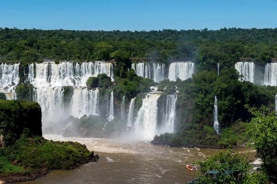 Helicóptero panorámico sobrevolando la cortina de agua y el cañón selvático de las Cataratas del Iguazú.