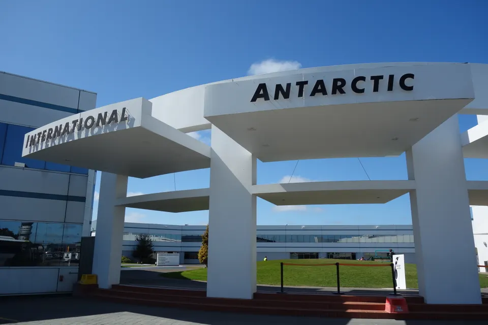 Vehículo oruga antártico Hagglund y pingüinos azules en el Centro Antártico Internacional.