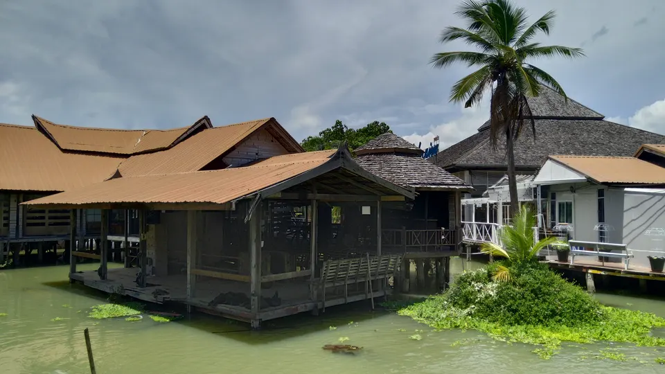 Casas de madera sobre pilotes y barcas comerciales en el Mercado Flotante de las Cuatro Regiones de Pattaya.