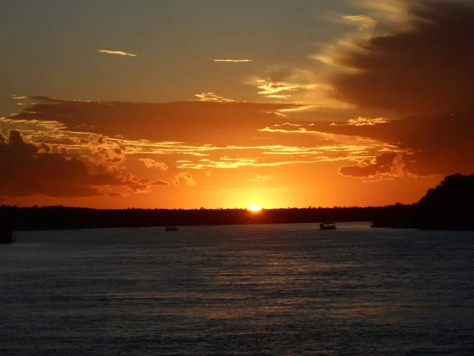Espectacular atardecer anaranjado reflejado sobre las corrientes del río Zambeze en Zimbabue.