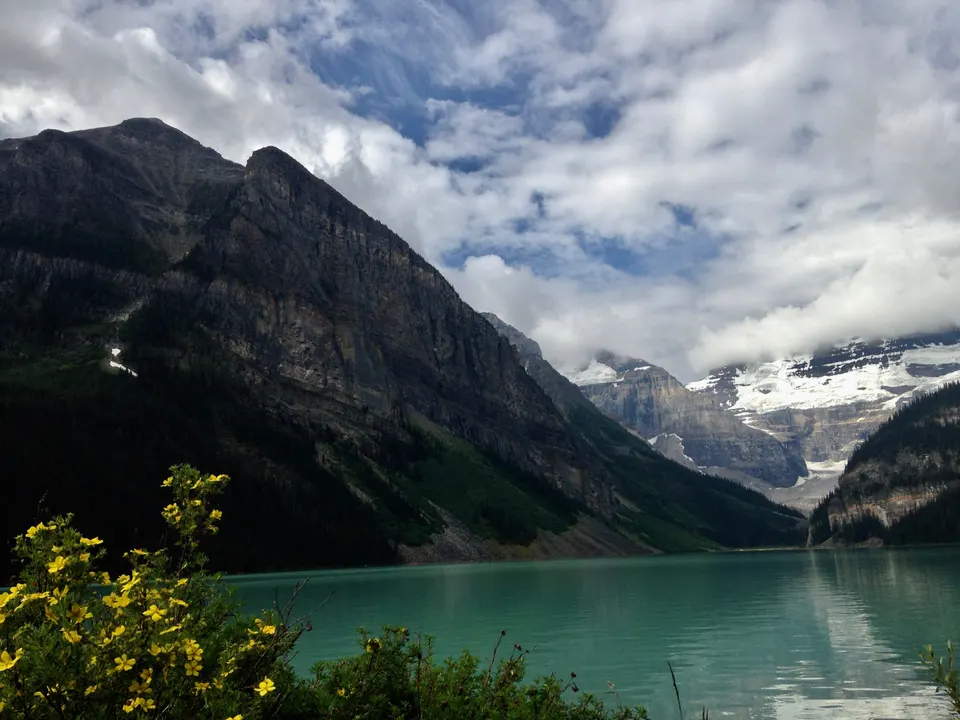 El lago glaciar Lake Louise con el Monte Victoria nevado al fondo reflejado en las aguas esmeralda.