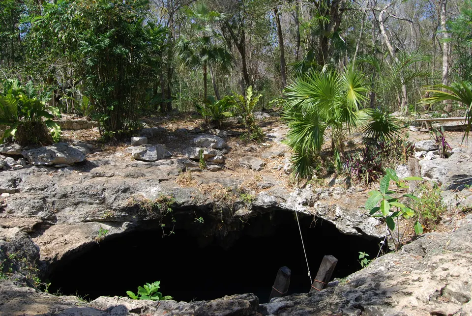 Oquedades de roca natural y escaleras de madera en el Cenote Calavera en Tulum.