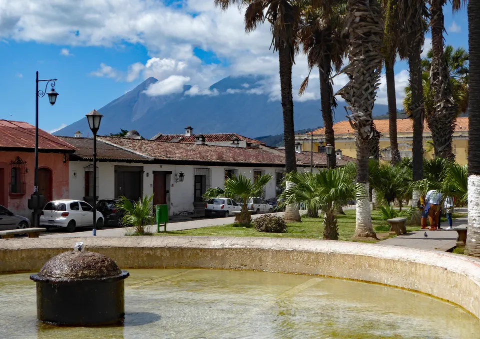 Lavadero colonial público del Tanque la Unión y plaza con palmeras en Antigua Guatemala.