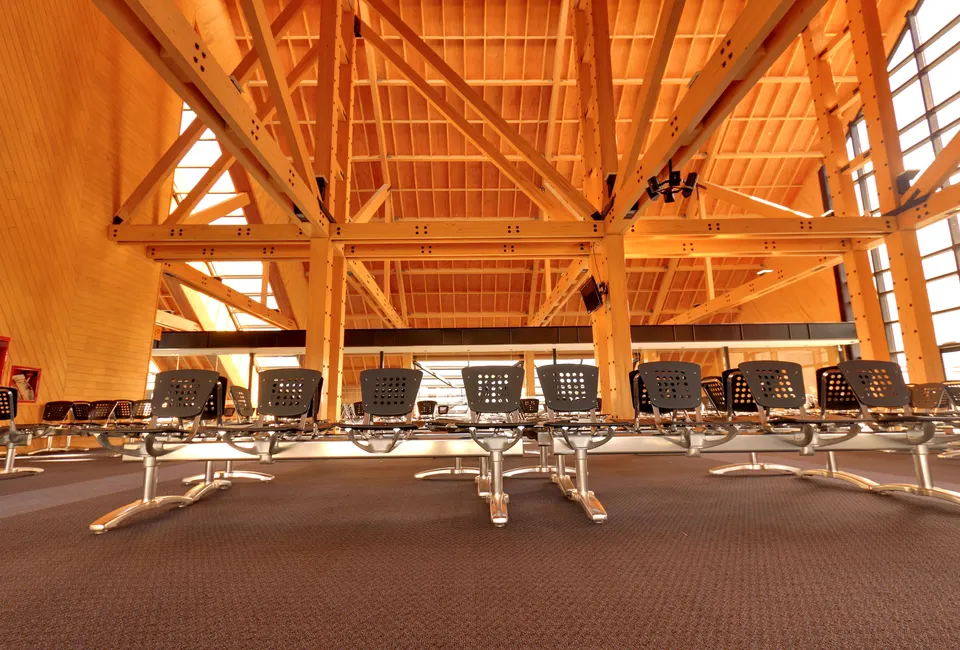 Sala de preembarque del Aeropuerto Internacional de Ushuaia Malvinas Argentinas con su distintiva arquitectura de madera y vista a la bahía.