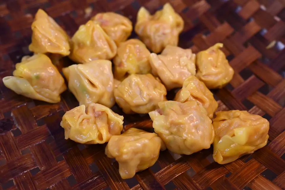 Variedad tradicional de cestas de bambú con dim sum al vapor, dumplings y salsas de la gastronomía asiática.
