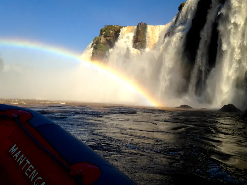 Embarcación inflable bimotor del Macuco Safari aproximándose al pie de los saltos de las cataratas en el río Iguazú.