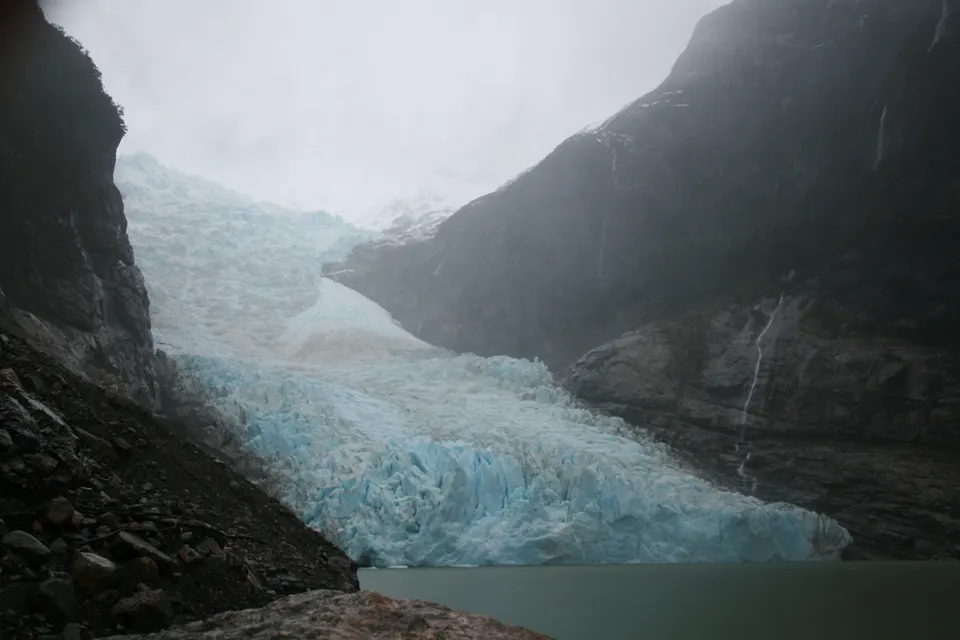 Masa de hielo glaciar del Glaciar Serrano cayendo sobre una laguna con témpanos flotantes en el fiordo Última Esperanza