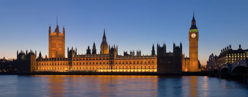 Vista panorámica del Palacio de Westminster y el puente sobre el río Támesis iluminados.