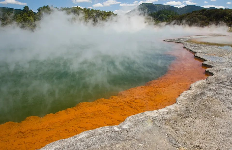 La colorida laguna termal Champagne Pool en Wai-O-Tapu con vapores minerales y bordes naranjas.