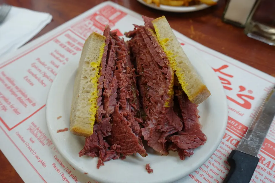 Sándwich clásico de carne ahumada (smoked meat) servido con mostaza sobre pan de centeno en Schwartz's Deli.