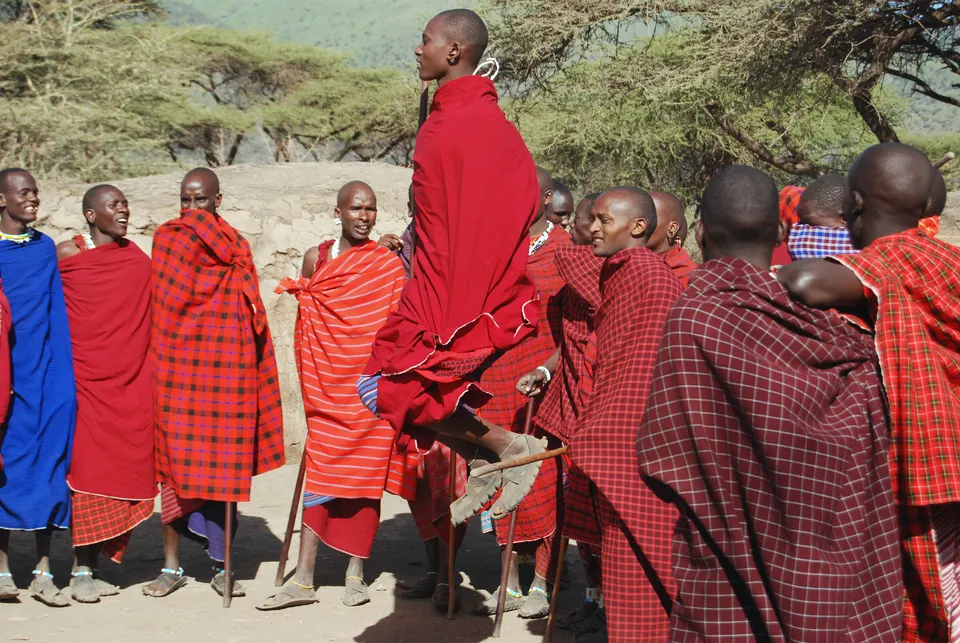 Guerreros masai keniatas vistiendo túnicas tradicionales shúka rojas y collares de cuentas.