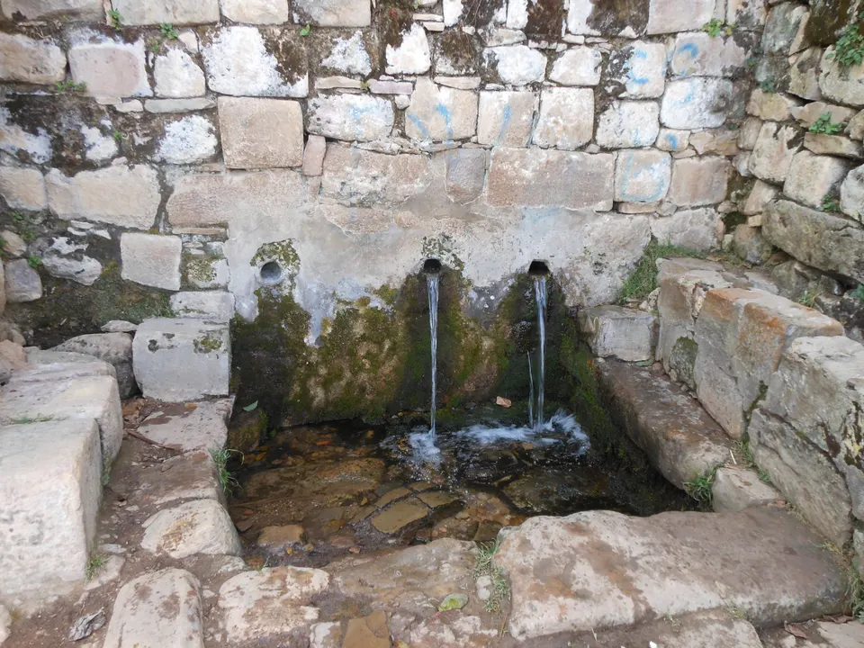 La milenaria Fuente del Inca con sus tres caños de agua sagrada y terrazas agrícolas en Yumani.
