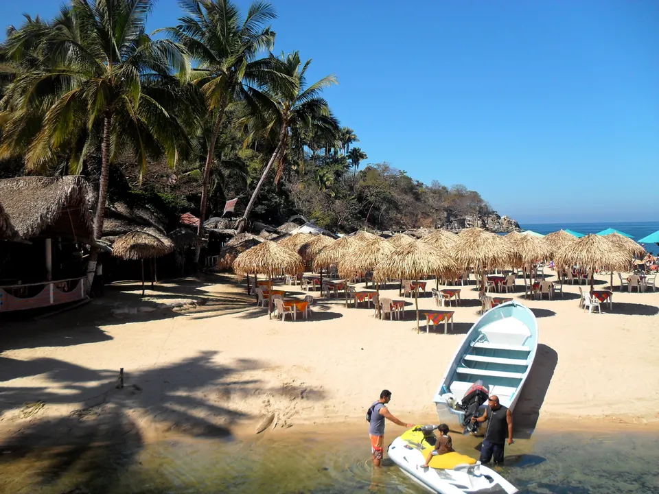 Bahía protegida de arena dorada y colinas selváticas en Playa Mismaloya, Puerto Vallarta.