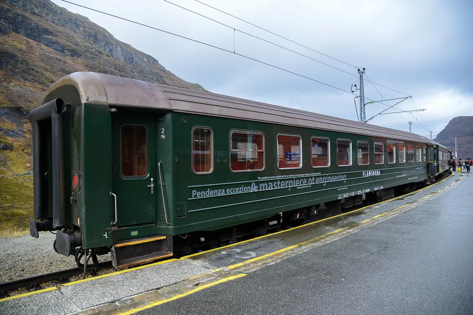 Tren del ferrocarril de Flåmsbana descendiendo entre cascadas y valles verdes en Flåm.