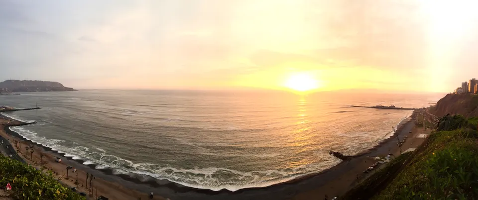 Acantilados verdes de la Costa Verde y el malecón de Miraflores bordeando el océano Pacífico en Lima