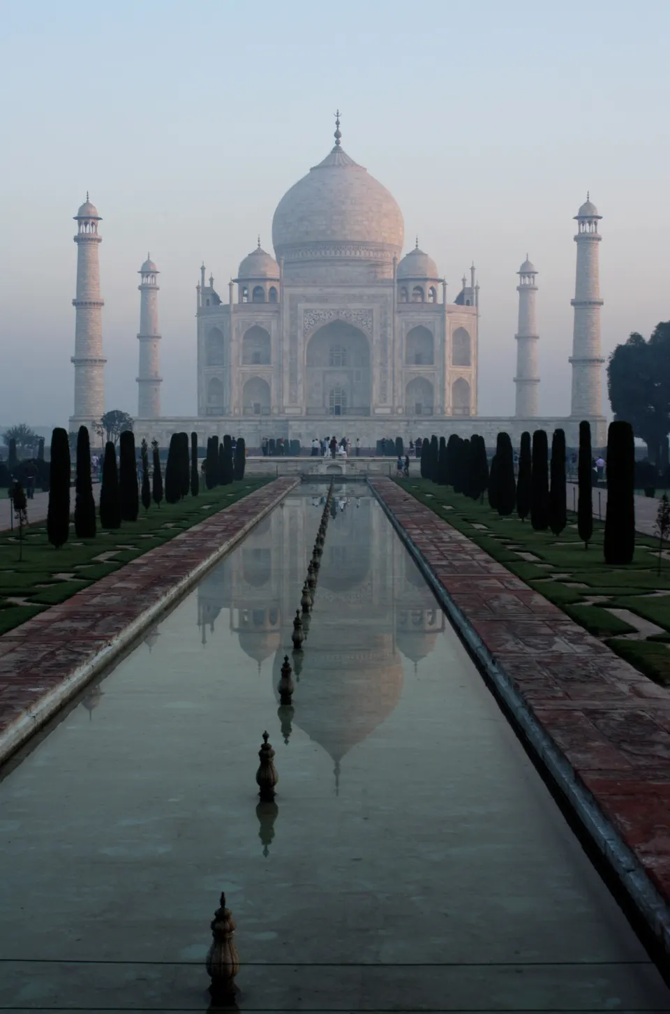 Mausoleo de mármol blanco del Taj Mahal resplandeciendo bajo la suave luz dorada del amanecer en Agra, India.