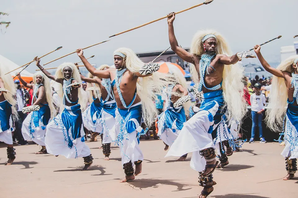 Bailarines ruandeses interpretando la danza tradicional guerrera Intore con tocados y lanzas.