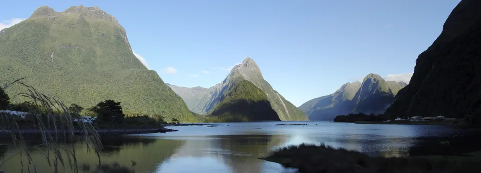 El majestuoso pico Mitre Peak elevándose sobre las aguas tranquilas del fiordo de Milford Sound.