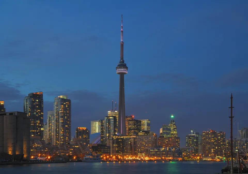 Skyline nocturno de Toronto con la Torre CN iluminada sobre el lago Ontario.