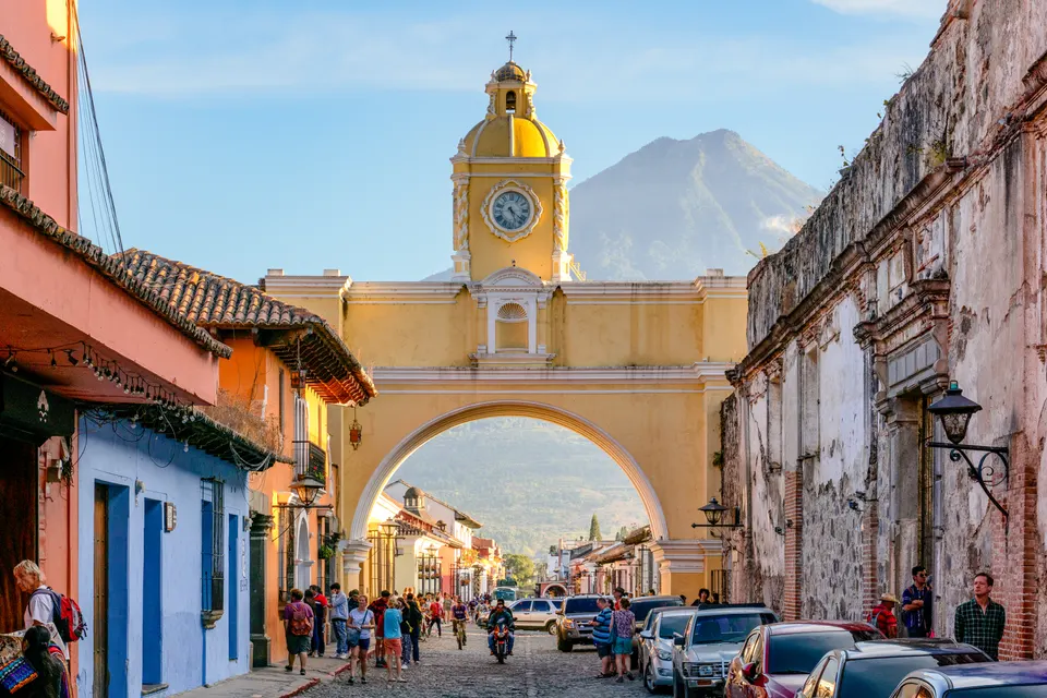El emblemático Arco de Santa Catalina en Antigua Guatemala con los volcanes de fondo.