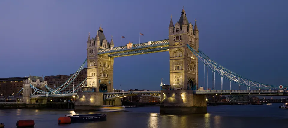 El Puente de la Torre (Tower Bridge) iluminado al atardecer sobre el río Támesis en Londres, Inglaterra.