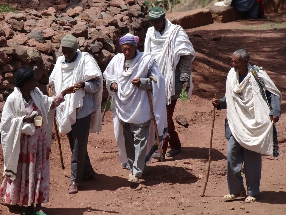 Peregrinos y muros tallados en la roca de la iglesia monolítica Bete Giyorgis en Lalibela.