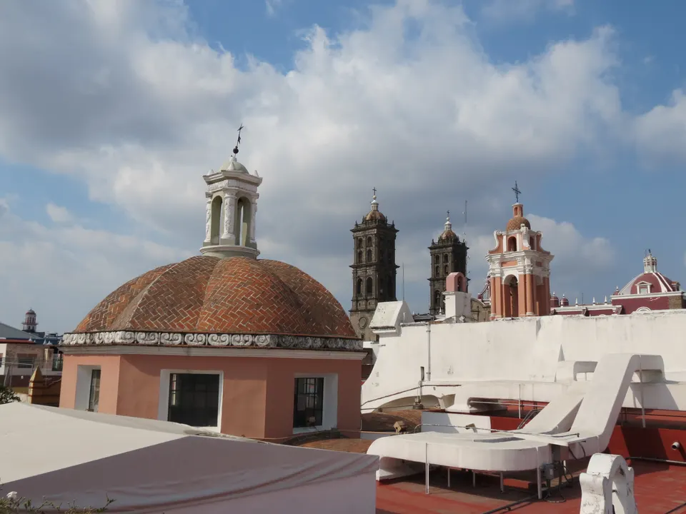 Cúpulas coloniales y campanarios de Puebla vistos desde la terraza contemporánea del Museo Amparo.