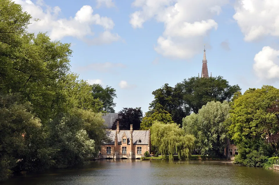 El estanque de Minnewater, conocido como el Lago del Amor, con la antigua casa del esclusero al fondo, en Brujas.