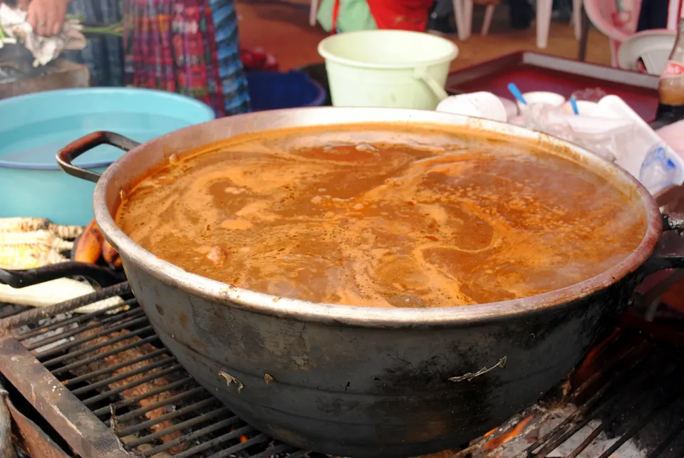 Olla de pepián tradicional guatemalteco cocinado a fuego lento con especias y semillas tostadas.