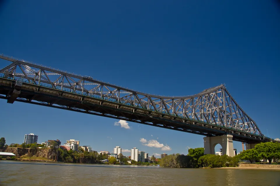 Estructura de acero del Story Bridge cruzando el río Brisbane con ferris CityCat navegando.