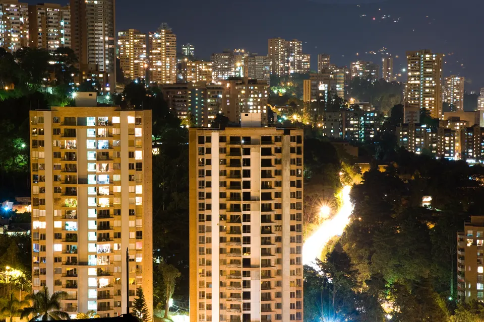 Sector de El Poblado iluminado al atardecer en Medellín con sus torres residenciales y áreas comerciales