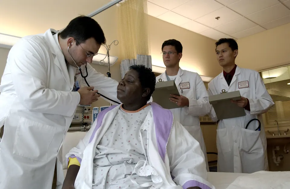 Médico examinando a un paciente con estetoscopio durante una consulta médica hospitalaria.