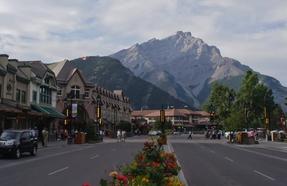 Banff Avenue en el corazón de la villa alpina con la silueta imponente de Cascade Mountain al fondo.