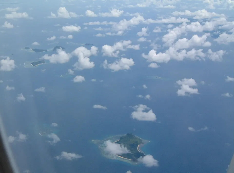 Vista aérea panorámica de las islas de Fiyi con aguas turquesas, arrecifes de coral y playas de arena blanca.