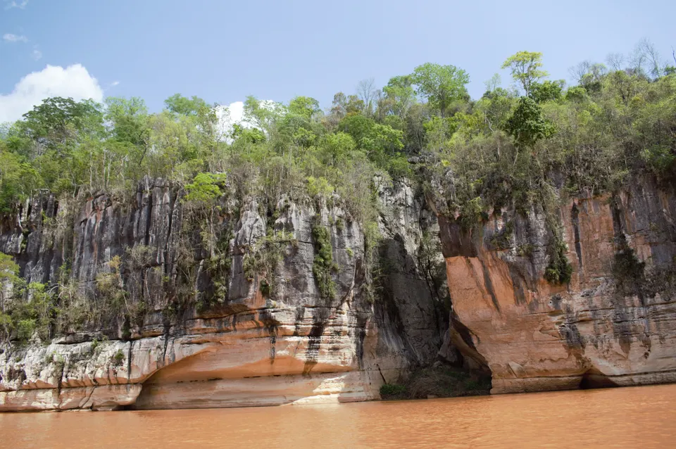 Paredes verticales de roca rojiza flanqueando el paso del río Manambolo recorrido en piragua pirogue.