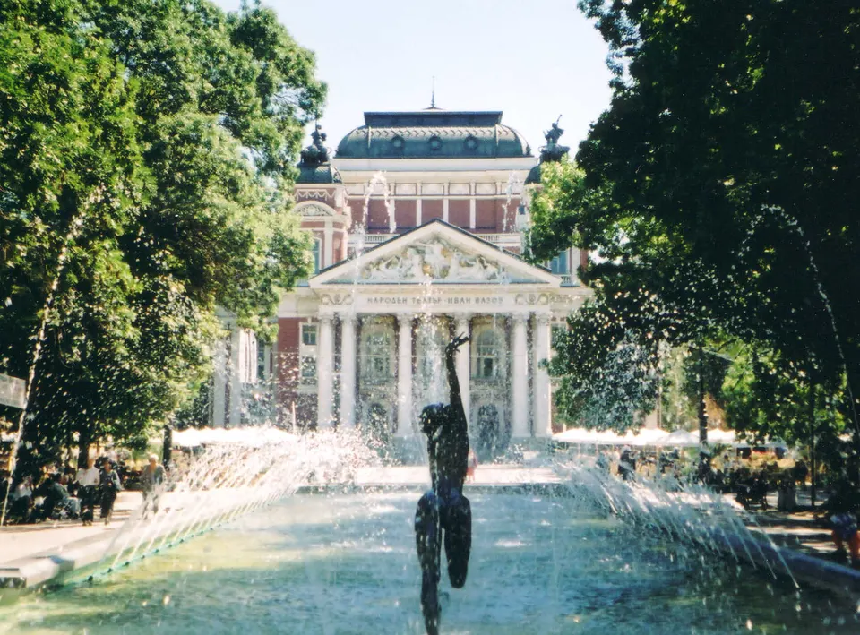 Fachada neoclásica rojiblanca del Teatro Nacional Ivan Vazov y sus fuentes en el Jardín de la Ciudad.