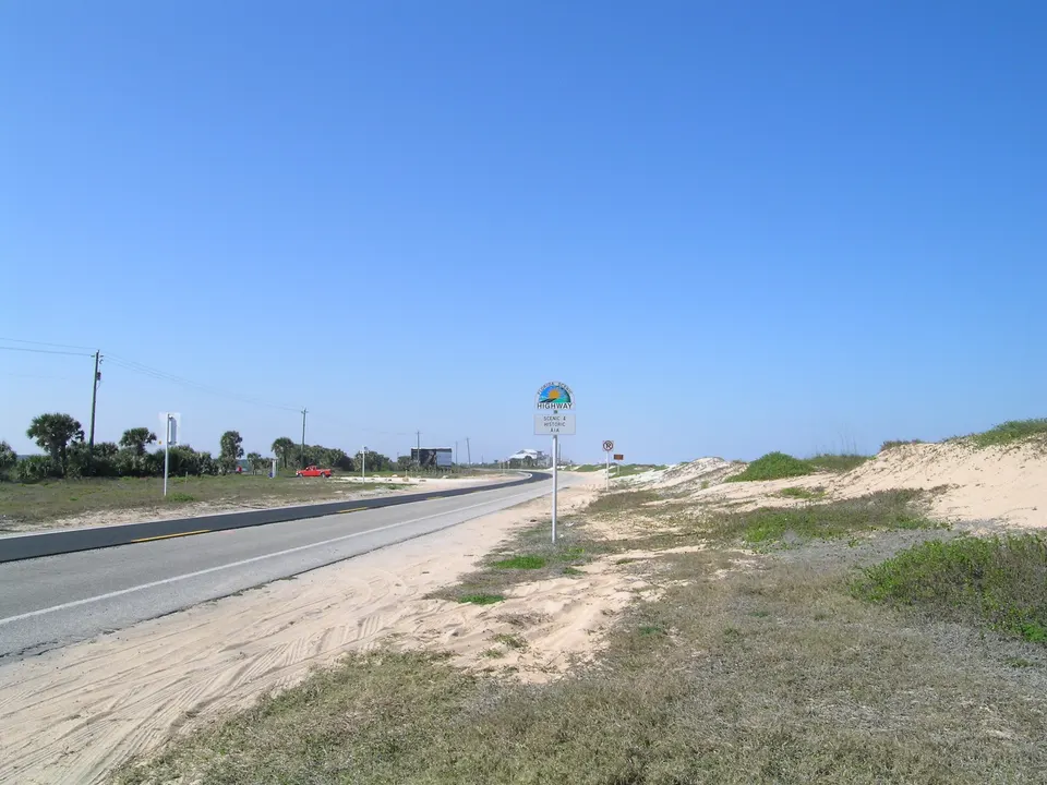 Conduciendo un coche de alquiler por una carretera costera panorámica junto al mar.