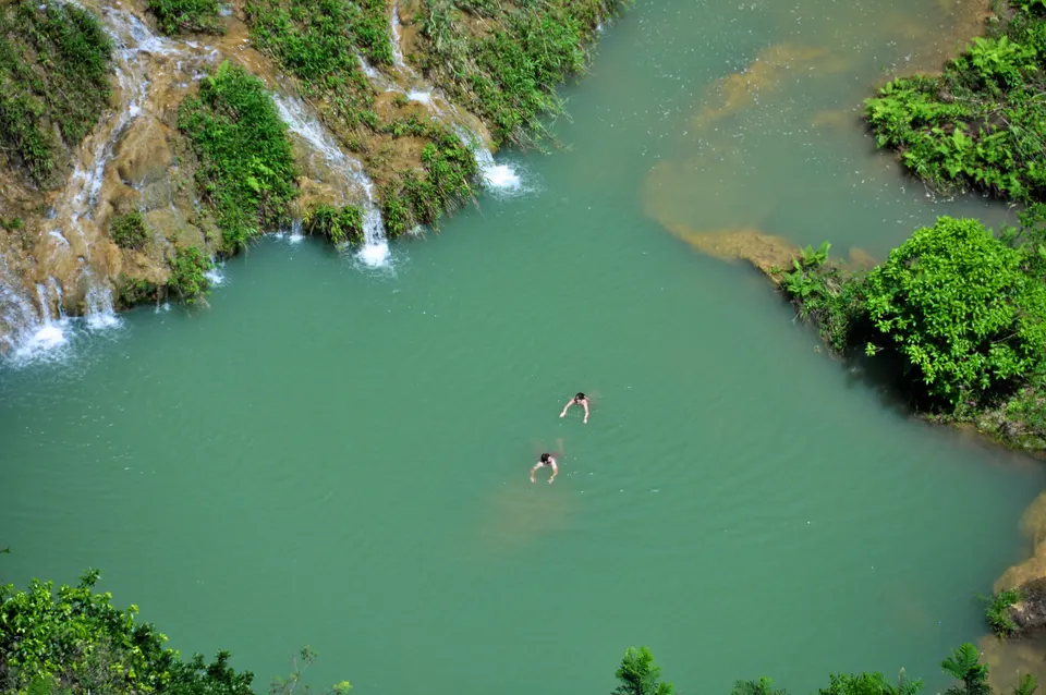 Viajeros nadando y relajándose en las cálidas aguas esmeraldas de las pozas de Semuc Champey.