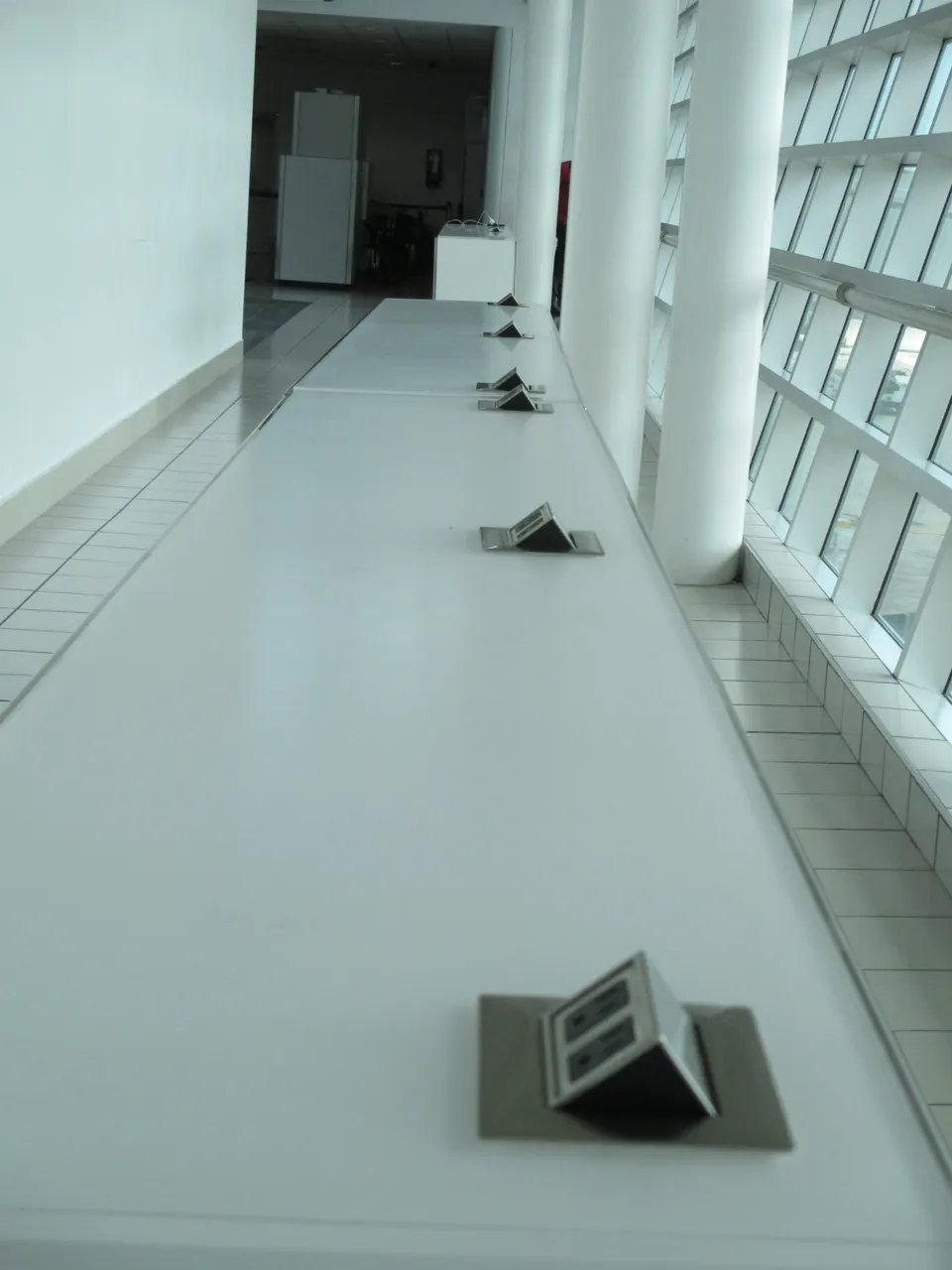 Puntos de recarga eléctrica y enchufes para dispositivos en sala de espera del aeropuerto.