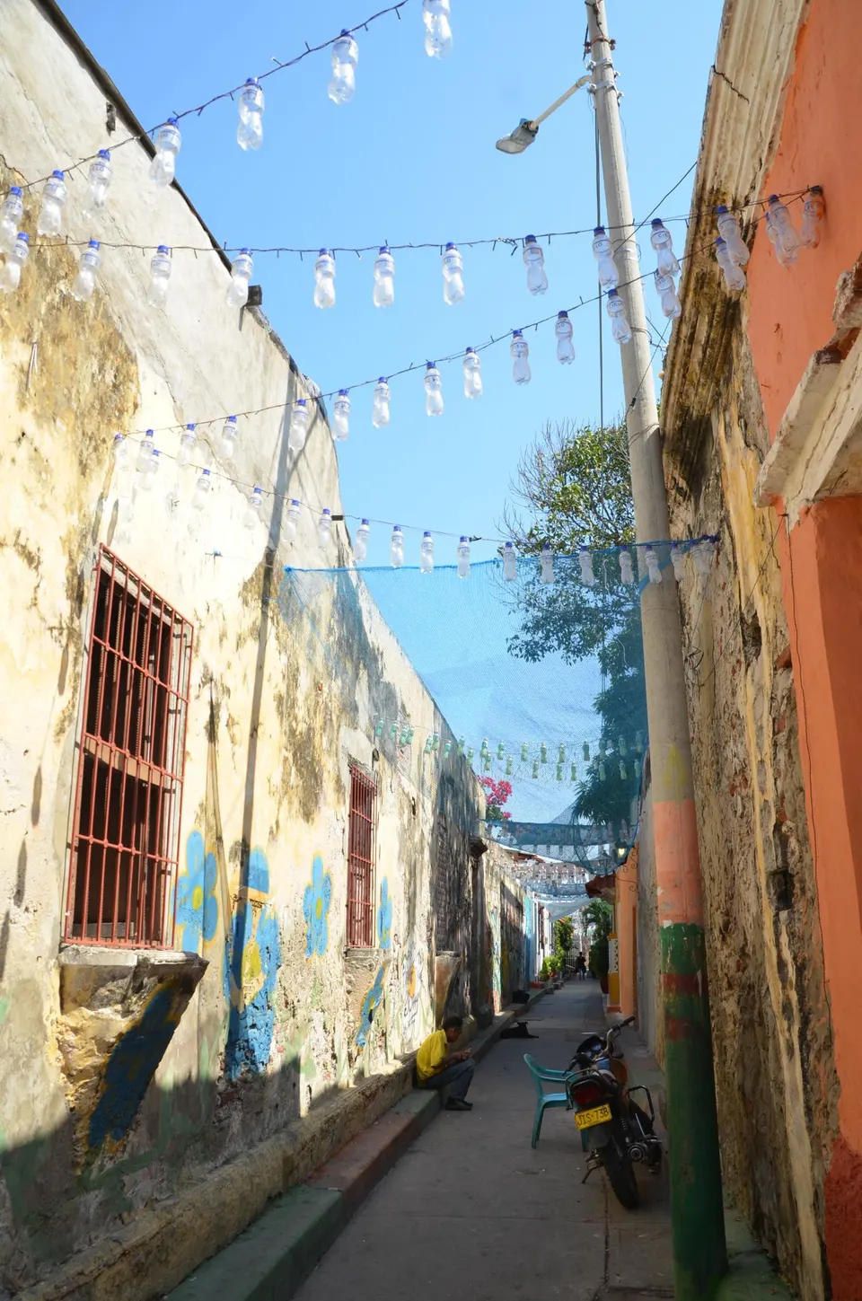 Calles coloridas con sombrillas colgantes, banderas y muralismo vibrante en el barrio Getsemaní