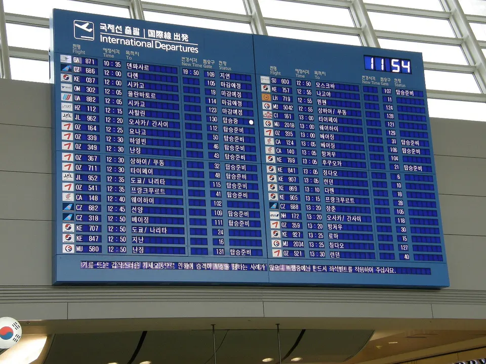Gran panel electrónico de información de salidas de vuelos en una terminal de aeropuerto internacional.