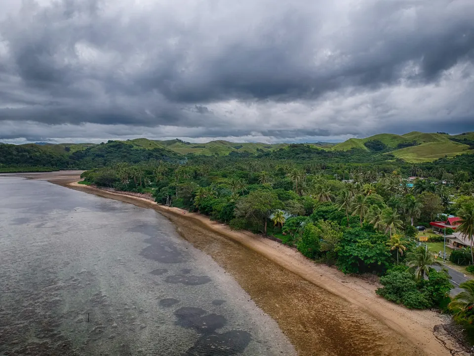 Litoral de la Costa de Coral en Viti Levu con arrecifes de coral protegidos, aguas turquesas y palmeras.