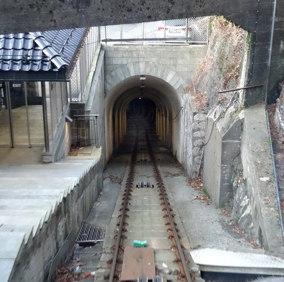 Vagón del funicular Fløibanen ascendiendo por la ladera boscosa hacia la cima del monte Fløyen.
