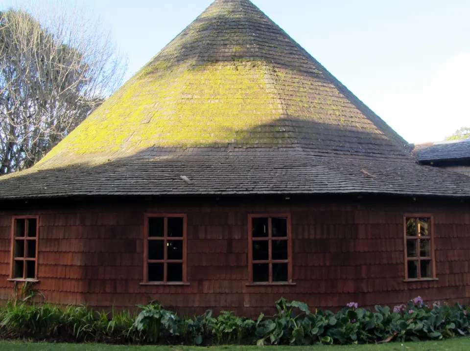 Construcciones coloniales de madera de alerce y jardines floridos en Frutillar Bajo