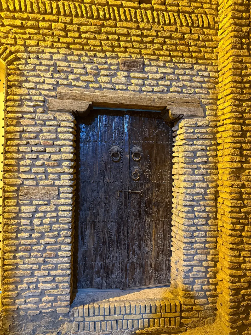 Puerta tradicional de madera y arquitectura de arcilla en el casco antiguo de Ouled el Hadef.