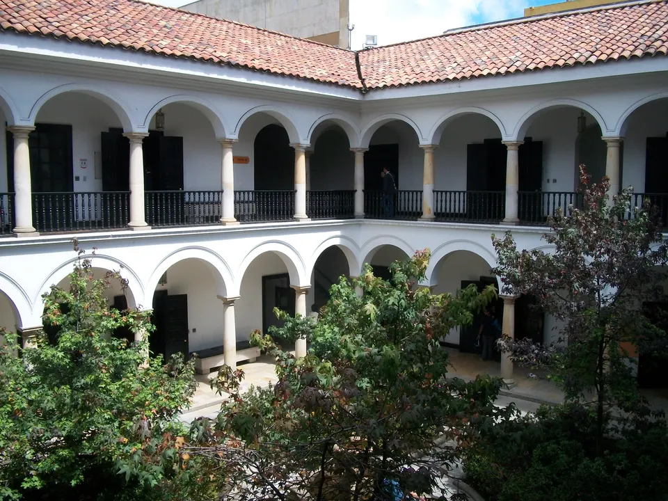 Claustro colonial con fuente de piedra y vegetación en el Museo Botero de Bogotá